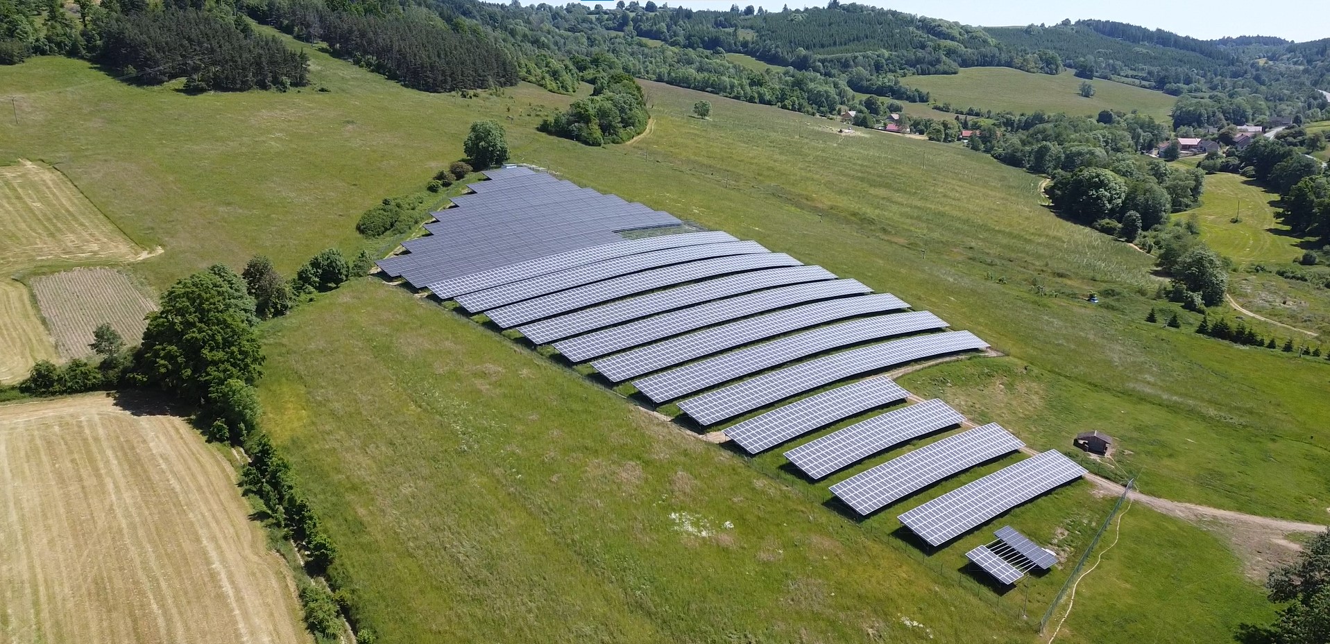 Fotovoltaická elektrárna na poli v kopcovitém terénu